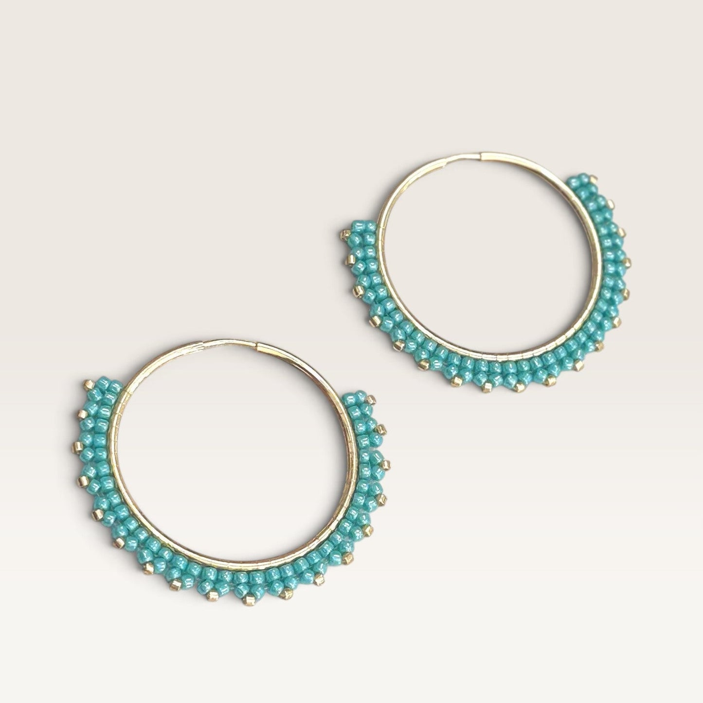 Ritelia Elena hoop earrings featuring turquoise Miyuki beads hand-woven onto gold-plated rings.