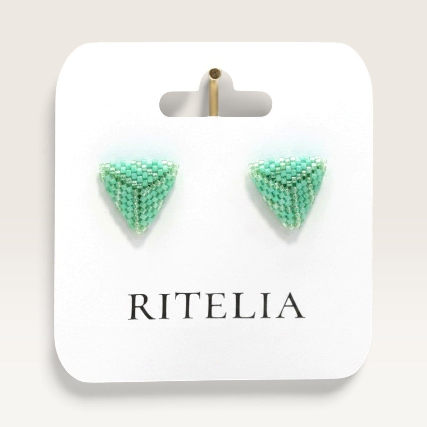 Ritelia handmade triangle stud earrings in jade green Miyuki Japanese beads on a branded display card.