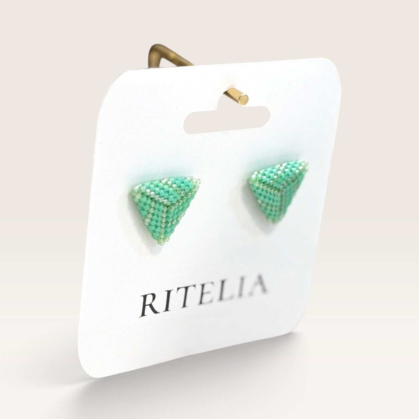 Ritelia handmade jade green triangle stud earrings crafted with Japanese Miyuki beads on a branded display card.
