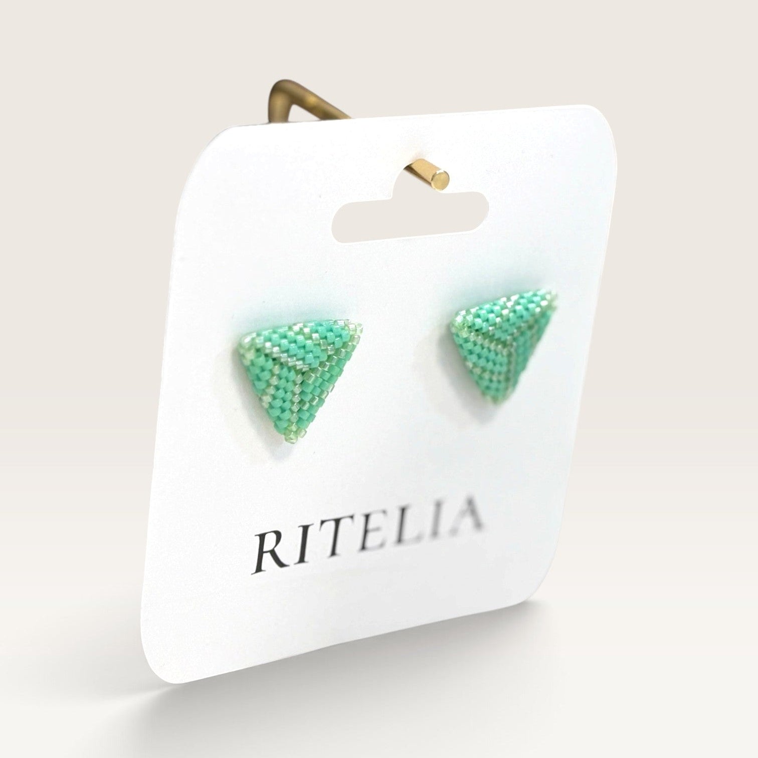 Ritelia handmade jade green triangle stud earrings crafted with Japanese Miyuki beads on a branded display card.