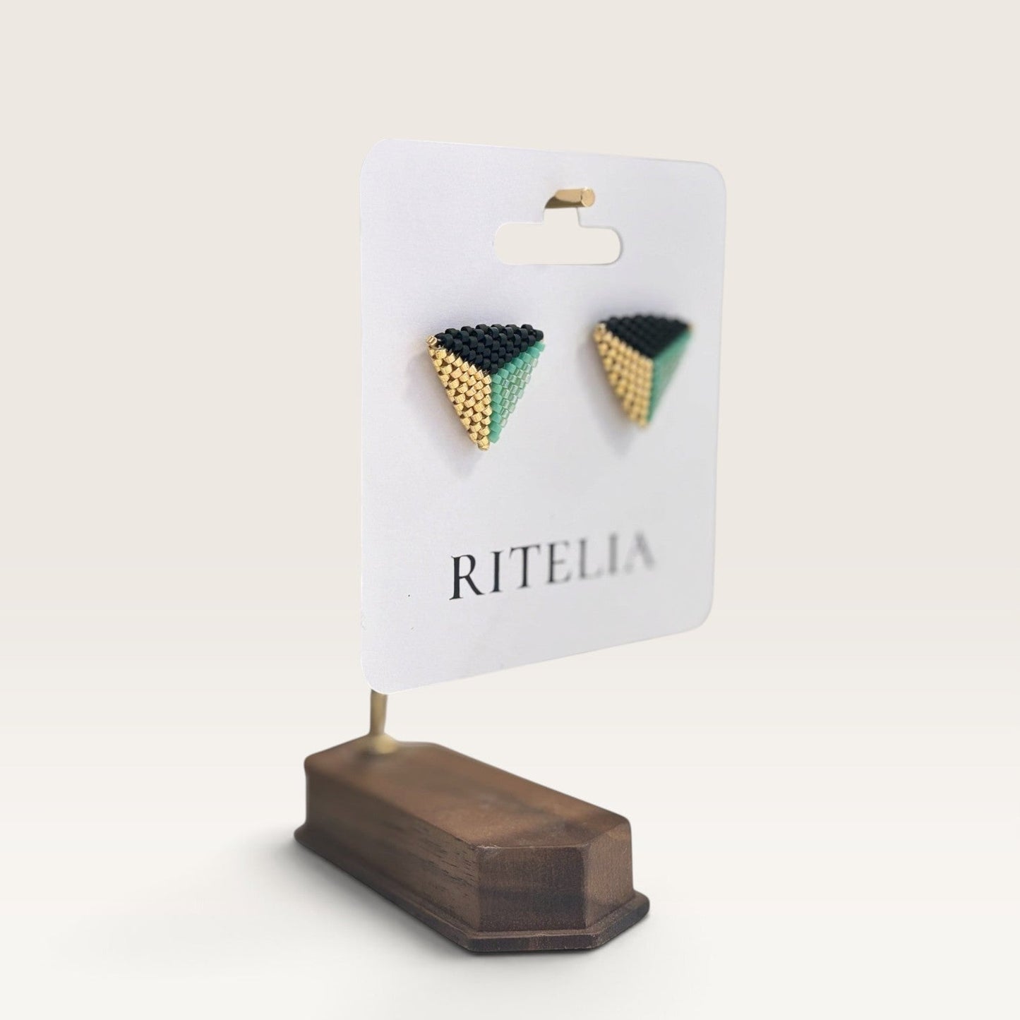 Ritelia Valentina triangle earrings handmade with black, mint green, and gold Miyuki beads on a display card.